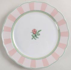 a pink and green plate with a rose on the center, sitting on a white surface