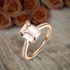 an engagement ring with a pink tourmaline stone and diamonds on the side, in front of roses