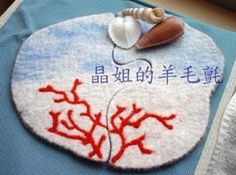 a blue towel with red corals on it and a seashell in the middle