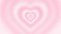 a heart shaped object is in the middle of a blurry background with pink and white colors