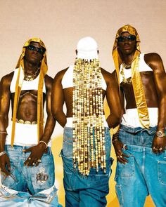 three black men wearing gold jewelry standing next to each other