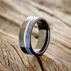 a wedding ring with blue and black wood inlays on the outside of it