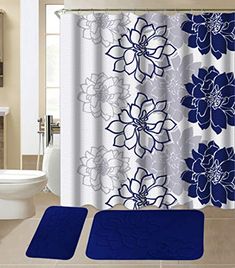 a bathroom with blue and white flowers on the shower curtain, toilet seat covers and rugs