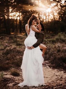 a woman in a white dress is hugging a man