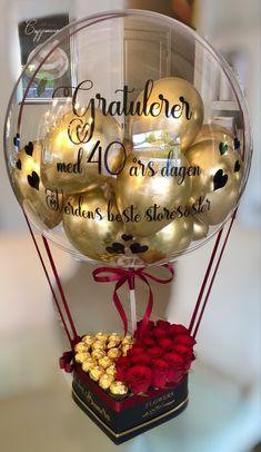 a balloon filled with lots of gold and red balls on top of a glass table