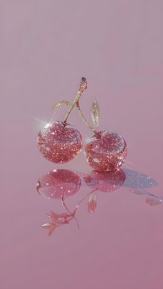 two pieces of glass sitting on top of a pink surface with water droplets around them