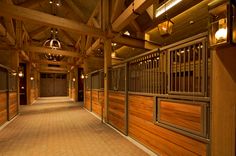 the inside of a horse barn with wooden walls and stalls on either side of it