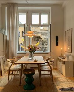 a dining room with a table and chairs next to a window