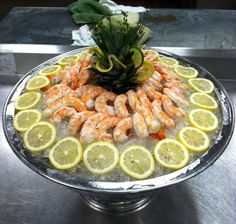 a platter filled with shrimp and lemon slices