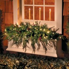 a window box filled with christmas lights and greenery