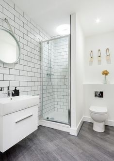 a white bathroom with gray flooring and tile walls