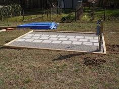 a backyard area with a concrete slab and blue tarp