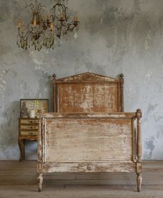 an old wooden bed in a room with a chandelier