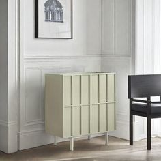 a chair and cabinet in a room with white walls