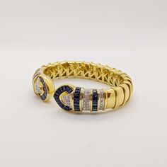 For Sale on 1stDibs - No details were spared in this beautiful 18 karat yellow gold cuff bracelet. Long tapered blue sapphires and pave round brilliant diamonds are set forming Luxury Gold Diamond Bracelet With Sapphire, Yellow Gold Cuff Bracelet, Gold Cuff Bracelet, Gold Bracelet Cuff, Gold Cuffs, Brilliant Diamond, Karate, Round Brilliant, Cuff Bracelet