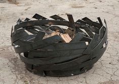 a metal sculpture sitting on top of a cement ground