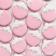 some pink and white decorated cookies on a table