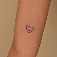 a small heart tattoo on the arm