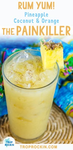 a drink in a glass with a slice of pineapple on the rim and text overlay reading rum yum, pineapple coconut & orange the pankiller