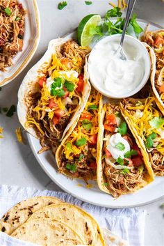 shredded beef tacos on a plate with sour cream