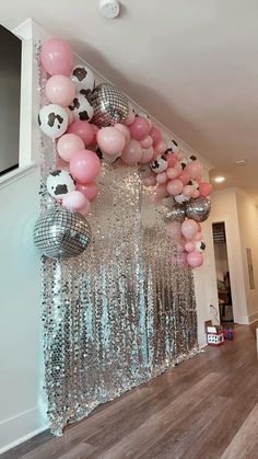 a room filled with lots of pink and silver balloons