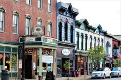 a row of buildings on the side of a street with cars parked in front of them