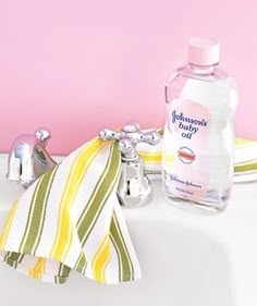 a bottle of deodorant sitting on top of a sink next to a towel