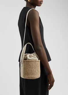 Find CHLOÉ Chloé Raffia Bucket Bag on Editorialist. The Chloé raffia bucket bag is crafted from woven raffia and features a canvas top handle, leather shoulder strap, canvas panels with metallic logo embroidery, logo-debossed leather base, and an internal leather patch pocket. The bag is fully lined and has a drawstring fastening top. It measures 5.5 inches in width, 6.5 inches in height, and 5.5 inches in depth. The top handle drop is 6 inches and the shoulder strap drop is 18 inches. Luxury Beige Bucket Bag With Intrecciato Weave, Luxury Woven Leather Straw Bucket Bag, Luxury Straw Bucket Bag With Woven Leather, Luxury Straw Bucket Bag With Bamboo Handle, Luxury Natural Pouch Bucket Bag, Luxury Natural Color Pouch Bucket Bag, Beige Bucket Bag With Intrecciato Weave And Top Handle, Beige Top Handle Bucket Bag With Intrecciato Weave, Chic Bucket Bags With Intrecciato Weave