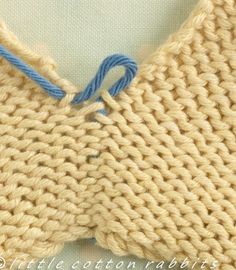 a close up of a knitted piece of cloth with blue thread on top and bottom