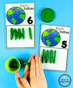 hands are holding green markers to match the numbers on earth and counting them in different colors