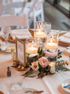 the table is set with candles and place settings for guests to sit down at it