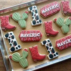 decorated cookies in the shape of cowboy boots and boots on a cookie sheet with words