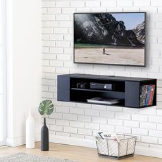 a flat screen tv mounted to the side of a white brick wall in a living room