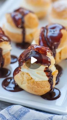 chocolate sauce drizzled on top of cream puffs in a white plate