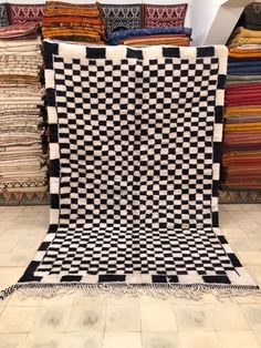 a black and white checkerboard quilt on display in a room filled with rugs