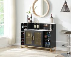 a black and gold bar with wine bottles on it in front of a round mirror