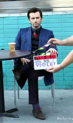 a man sitting at a table holding a sign