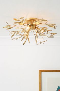 a light that is on above a bed in a room with white walls and flooring