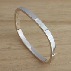 This is Solid 925 Sterling Silver Plain Square Shape Hinged Bangle Bracelet.  London Assay Office Hallmarked which is warranty for the purity being 925 sterling silver you  can be sure that you are buying genuine piece of jewellery.   Approx. weight: 11.5 grams.        Internal measures: 58mm x 51mm         Width: 5mm  Presented in gift box.    Thank you for looking! Sterling Silver Bangle With Shiny Finish For Anniversary, Anniversary Sterling Silver Bangle With Silver Clasp, Classic Sterling Silver Bangle Bracelet, Classic Sterling Silver Bracelet For Anniversary, Classic Sterling Silver Bangle Stamped 925, Classic Sterling Silver Bangle For Anniversary, Classic 925 Stamped Bangle For Anniversary, Sterling Silver Bracelet With Shiny Finish For Anniversary, Modern Sterling Silver Rectangular Bracelet