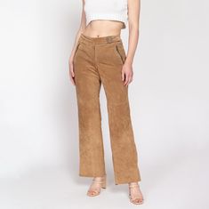 Vintage early 90s soft tan suede leather pants with zippered from pockets, scalloped western snap back pockets, and a bootcut leg. They have a mid-rise, and a mock belt at the front of the waist. Shown clipped on the model in the first two photos.  Measurements and Condition: Fits like: Labeled size 10, women's medium Fabric: Suede leather, with a nylon/acetate lining Brand: Context Condition: Good, with light general wear, a 1/2" dark line on the right seat, and some small sections of faint gray discoloration at the front of the waist, at the back leg hems, and on the back pockets. Waist: 33" Hips: 40" - taken at the bottom of the zipper opening Rise: 9.5" Inseam: 31" Leg opening: 19" Shown on a 5'8" model with measurements of 35"-26"-38", usually wears a size small to medium. See our FAQ Casual Mid-rise Leather Bottoms, Brown Bottoms With Zipper Closure For Spring, Full-length Leather Bottoms For Spring, Full Length Leather Bottoms For Spring, Brown Suede Bottoms, Leather Bottoms With Zipper Closure For Spring, Fitted Suede Bottoms For Fall, Chic Brown Suede Bottoms, Suede Bottoms For Workwear In Fall