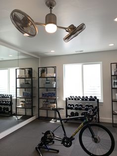 a bicycle is parked in the middle of a room with several shelves and ceiling fans