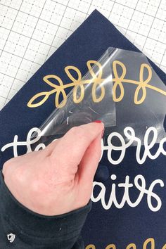 someone is writing on the back of a blue graduation cap with gold lettering and an arrow