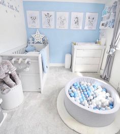 a baby's room is decorated in blue and white with lots of balls on the floor