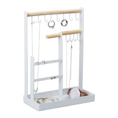 a white jewelry rack with three necklaces and two rings