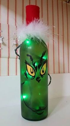 a green glass bottle with an evil face on it