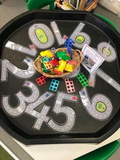 a child's play tray with numbers and dices on the side, sitting on top of a table