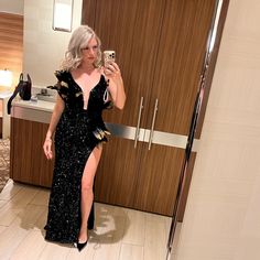 a woman in a black dress taking a selfie