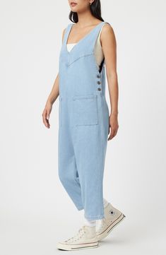 Rock a casual-cool vibe in this lightweight denim jumpsuit designed with front patch pockets and a cropped length. 23 1/2" inseam; 17 1/2" leg opening Side button closure Deep V-neck Sleeveless Front patch pockets 76% cotton, 24% rayon Machine wash, dry flat Made in Turkey High Rise Denim Blue Utility Jumpsuit, Casual Shortalls With Side Pockets, Casual Denim Shortalls With Pockets, Casual Relaxed Fit Shortalls, Casual Dark Wash Denim Jumpsuit With Side Pockets, Medium Wash Relaxed Fit Denim Jumpsuit With Bib Front, Medium Wash Straight Leg Shortalls In Casual Style, Medium Wash Straight Leg Shortalls, Medium Wash Straight Leg Shortalls Casual