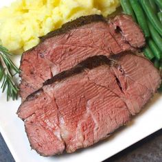 a white plate topped with meat and green beans