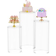 three clear containers with cupcakes and a cake in the middle one has a gold top